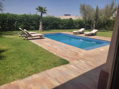 a swimming pool with two lounge chairs next to it at Villa isolée 4 façades avec piscine in Marrakech