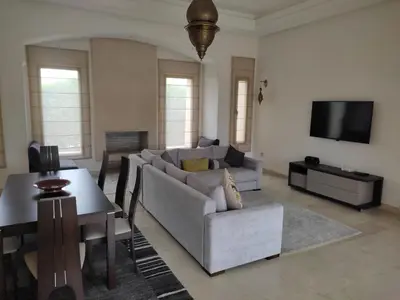 a living room with a couch and a table at Villa isolée 4 façades avec piscine in Marrakech