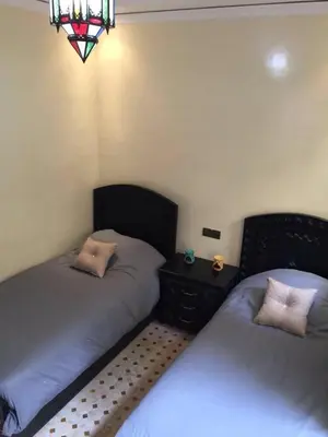 a bedroom with two beds and a stained glass window at Riad Syrine in Marrakech