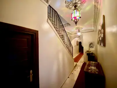 a hallway with stairs and a chandelier at Riad Jibraile in Marrakech