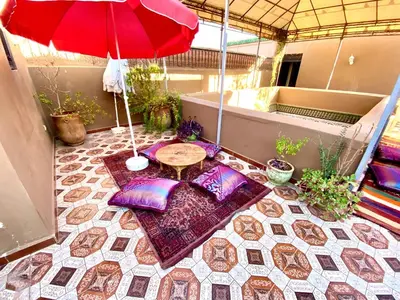 a small patio with a table and an umbrella at Riad Jibraile in Marrakech