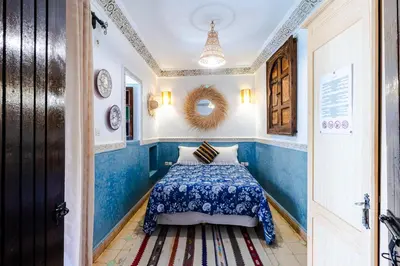 a bedroom with blue and white walls and a bed at Riad Davina in Marrakech