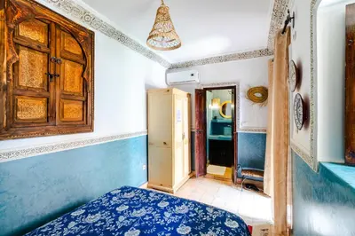 a bedroom with a blue bed and a hallway at Riad Davina in Marrakech