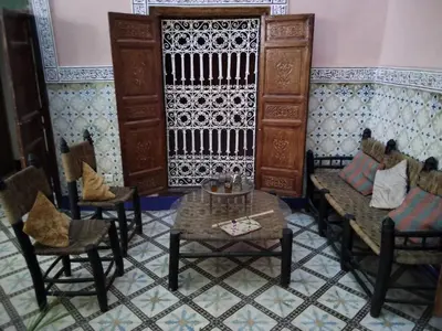 a room with chairs and a table in a room with a wall at Riad Bouchouari 33 in Marrakech