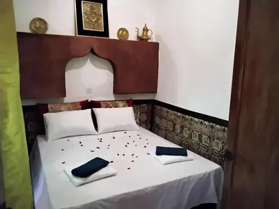 a bedroom with a bed with two napkins on it at Riad Bouchouari 33 in Marrakech
