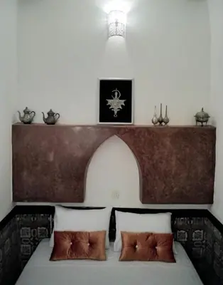 a bedroom with a bed with a wooden headboard at Riad Bouchouari 33 in Marrakech