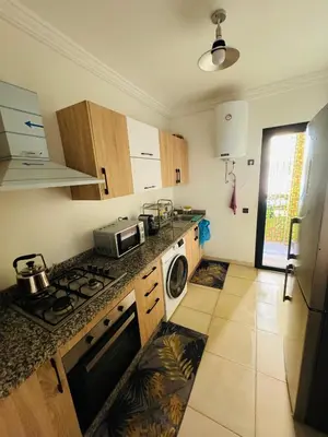 a kitchen with a stove top oven next to a sink at Appartement de luxe et moderne in Marrakech