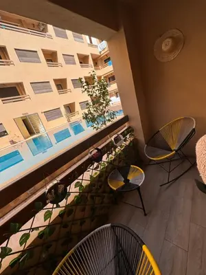 a balcony with two chairs and a large window at Appartement de luxe et moderne in Marrakech
