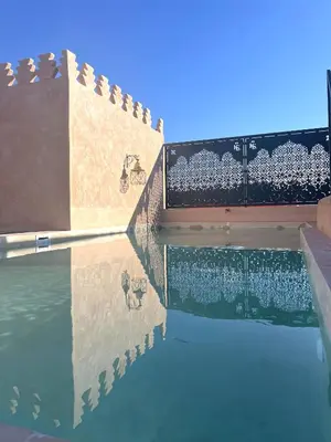 a pool with a reflection in the water at Riad Ksar Al Amal & Spa in Marrakech