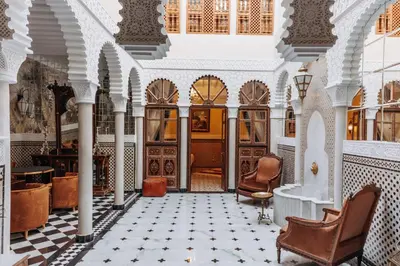 a lobby of a building with chairs and tables at Riad Ksar Al Amal & Spa in Marrakech