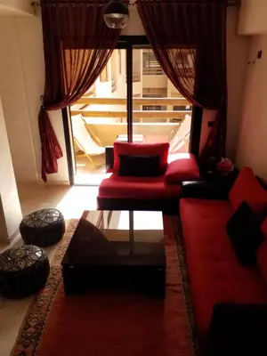 a living room with a red couch and a table at Agréable appartement au coeur de Guéliz, Marrakech in Marrakech