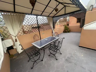 a patio with a table and chairs on a balcony at Dar El Azzouzi in Marrakech