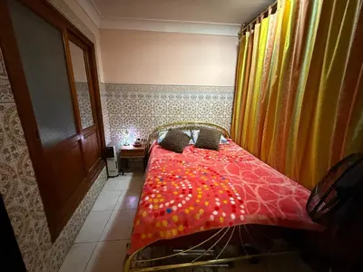 a bedroom with a bed with a red comforter at Dar El Azzouzi in Marrakech