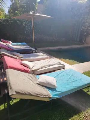 a group of mattresses sitting next to a swimming pool at Al Maaden Ryad 69 a Marrakesh in Marrakech