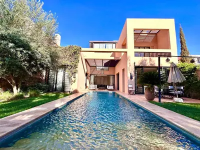 a house with a swimming pool in front of a house at Al Maaden Ryad 69 a Marrakesh in Marrakech