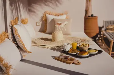 a table with a tray of food on a bed at Riad Tizou in Marrakech