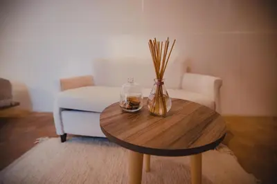 a coffee table with a vase of flowers and a chair at Riad Tizou in Marrakech