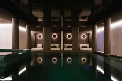 a swimming pool with pillows and a bed in a room at Riad Nyla Wellness and Spa in Marrakech