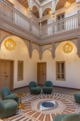 a lobby with chairs and a table and a staircase at Riad Nyla Wellness and Spa in Marrakech