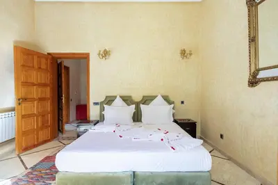 a bedroom with a white bed with red flowers on it at Villa près de golfs in Marrakech