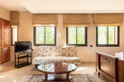 a living room with a couch and a tv at Villa près de golfs in Marrakech