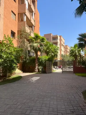 a cobblestone street in front of a building at Superbe appartement en résidence avec piscines in Marrakech
