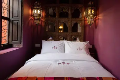 a bedroom with a large white bed with purple walls at Palais El Roucar in Marrakech