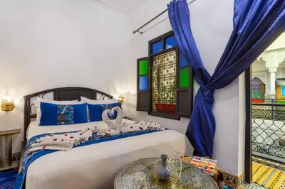 a bedroom with two beds and a table at Riad La Porte d'Or & SPA in Marrakech