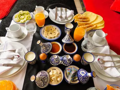a table filled with breakfast foods and orange juice at Riad La Porte d'Or & SPA in Marrakech