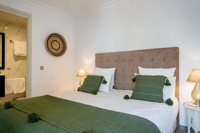 a bedroom with a large white bed with green pillows at Riad Dar Blanche & Spa in Marrakech