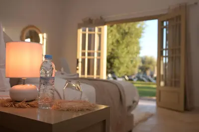 a bottle of water and a lamp on a table next to a bed at Villa Nour in Marrakech