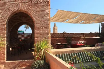 an outdoor patio with two arches and tables and chairs at Riad Samsara in Marrakech