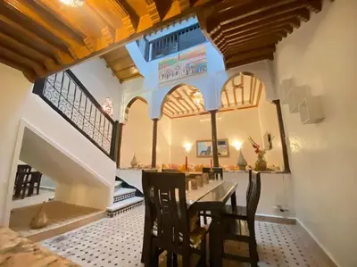 a dining room with a long table and chairs at Un Riad pour se divertir en famille & se détendre in Marrakech