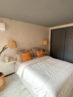 a bedroom with a large white bed with orange pillows at Vitality Home in Marrakech
