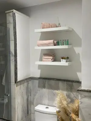 a bathroom with a toilet and shelves with towels at Vitality Home in Marrakech