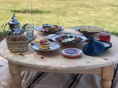 a wooden table with plates of food on it at Atlas Views By Golf Resort in Marrakech
