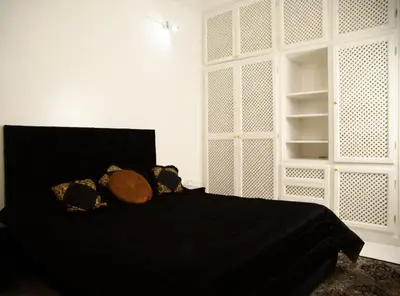 a bedroom with a black bed and a book shelf at Cosy Villa Sabah With Private Pool in Marrakech