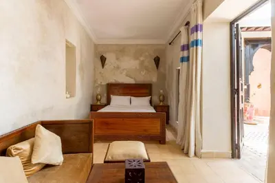 a bedroom with a bed and a couch at Riad les épices in Marrakech