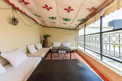 a room with a balcony with couches and a table at Riad les épices in Marrakech
