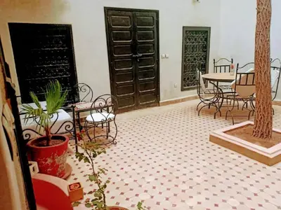 a room with chairs and tables and a table and chairs at Riad les épices in Marrakech