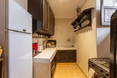 a small kitchen with a refrigerator and a stove at Riad les épices in Marrakech