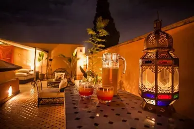 a table with two glasses of beer and a lantern at Riad Mounlight in Marrakech
