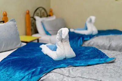 two white towels are laying on a bed at Hôtel Faouzi in Marrakech
