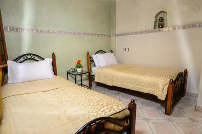 a room with two beds in a room at Hôtel Faouzi in Marrakech