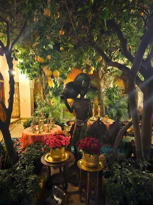 a statue of a woman in a garden with fruits and flowers at Riad Jnane d'Ô in Marrakech