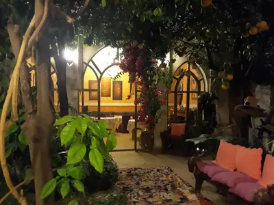 a living room filled with furniture and a tree at Riad Jnane d'Ô in Marrakech