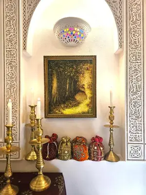 a table with candles and a painting on a wall at Riad Jnane d'Ô in Marrakech