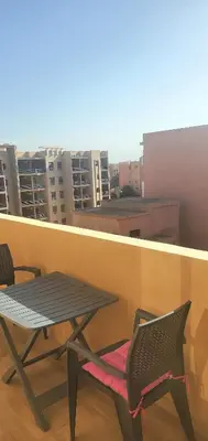 a table and chairs sitting on a balcony at appart Marrakech in Marrakech