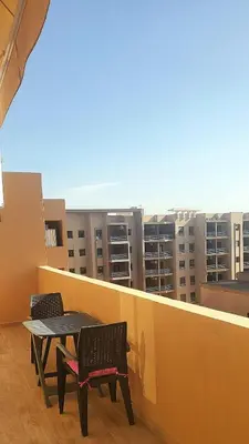 a balcony with a table and chairs on a building at appart Marrakech in Marrakech
