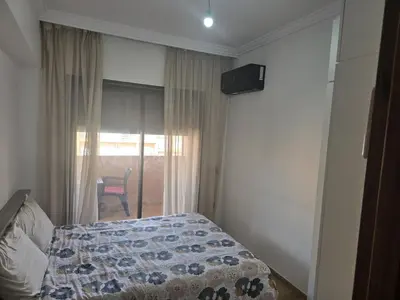 a bedroom with a bed and a window with a chair at appart Marrakech in Marrakech